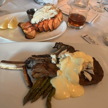 21 Main at North Beach signature dishes Prime Tomahawk Ribeye Steak, Coldwater Lobster Tail, Nueske's Bacon.
